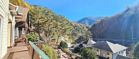A wooden deck with a view of a residential area and mountains.