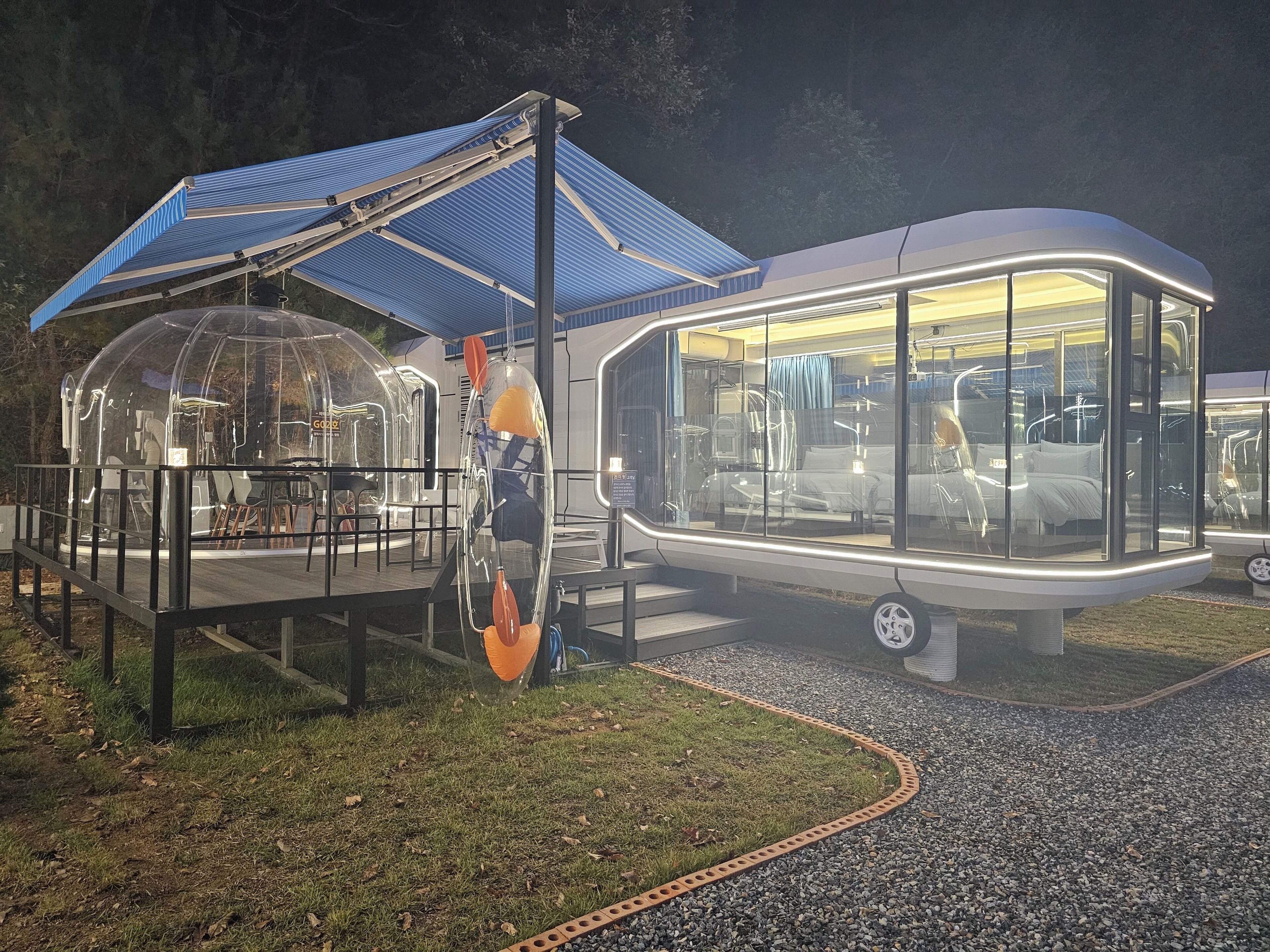 A modern, glass-enclosed structure with a blue roof, likely a hotel or resort.