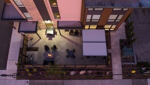 An outdoor patio area with a table and chairs, surrounded by a garden with plants and rocks. - The Kulshan Hotel (Sedro-Woolley)