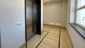Ein moderner Flur mit Holzboden, einer Tür und einem Fenster.