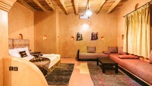A cozy room with a bed, sofa, and a small table. - Palais d'Ouzoud (Ait Taguella)
