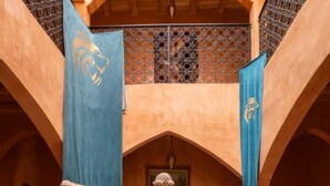A courtyard with a central fountain, arches, and blue banners. - Palais d'Ouzoud (Ait Taguella)