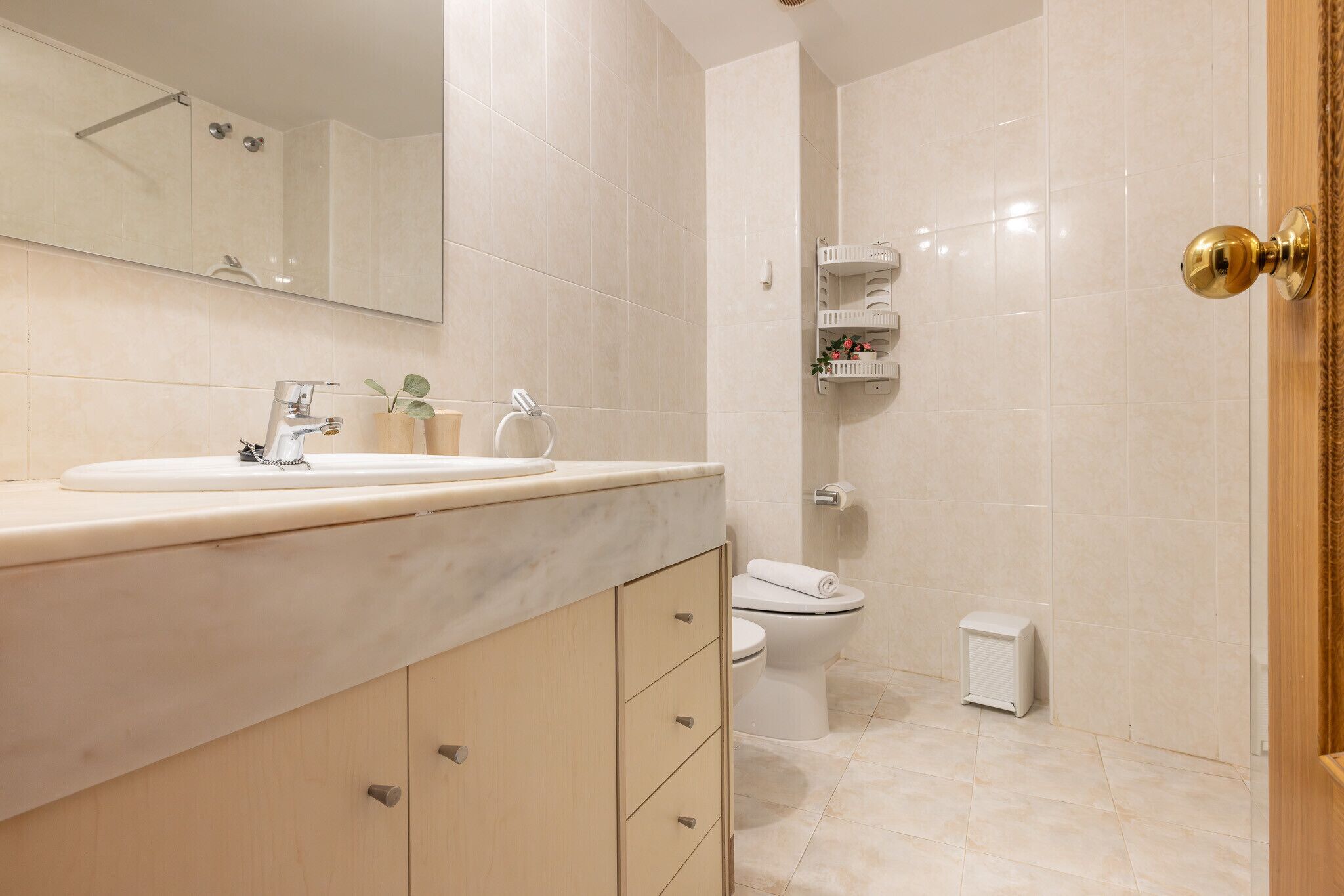 A bathroom with a sink, toilet, and shower.
