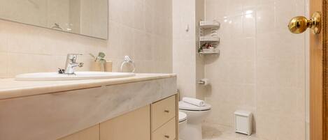A bathroom with a sink, toilet, and shower.