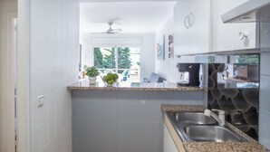 Cozinha moderna com bancadas de granito, pias de aço inoxidável e painel de parede com padrão preto.
