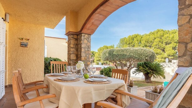 A table set for dining with a view of a garden and trees. - Casa Quimeta (L'Escala)
