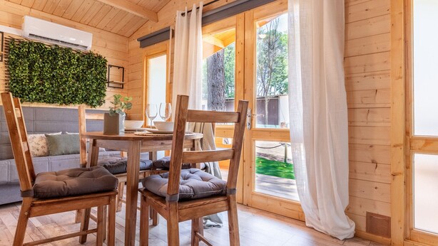 A wooden interior with a dining table, chairs, and a sofa. - Bungalow Forest (L'Escala)