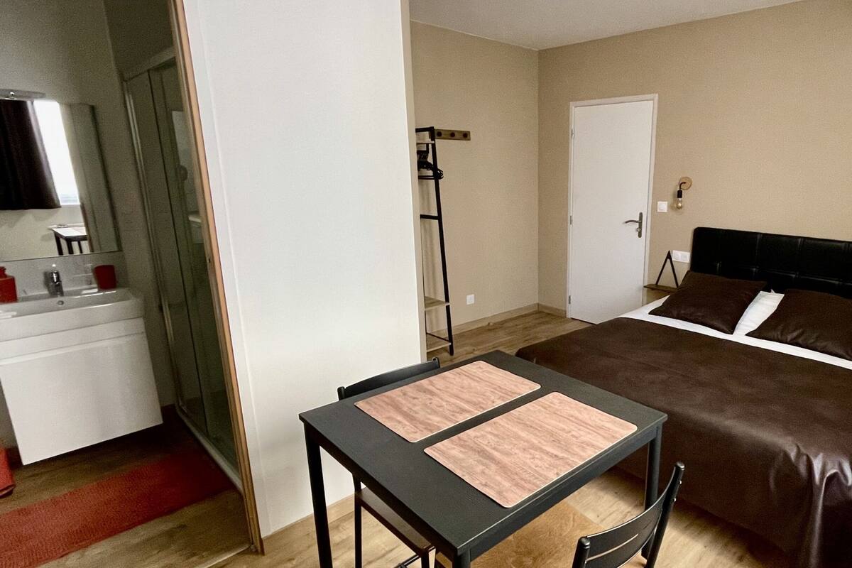 A bedroom with a bed, a desk, and a chair.