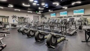 A gym with treadmills, elliptical machines, and weight equipment.