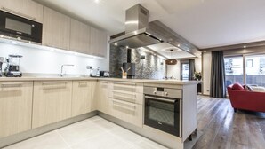 Una cocina moderna con una isla central, electrodomésticos de acero inoxidable y un salpicadero de piedra.