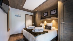 Une chambre moderne avec un grand lit, un plafond en bois et une ambiance chaleureuse.