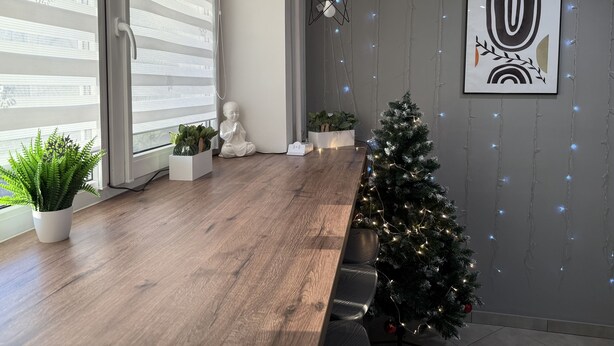 A modern interior with a wooden floor, a Christmas tree, and a Buddha statue. - Urban Rooms (Minsk)