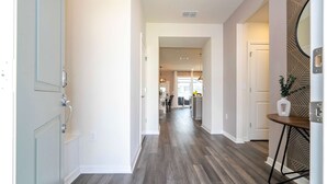 A hallway with wooden flooring, white walls, and a door on the left. - Family Friendly 5Bd Close to Disney Windsor Cay 1269 (Clermont)