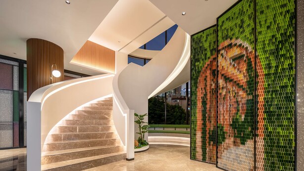 Ein modernes Interieur mit einer geschwungenen Treppe, einer grünen Mosaikwand und einer Holzvertäfelung.