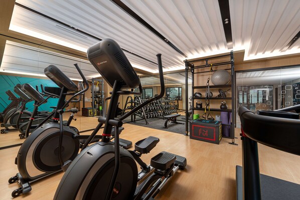 Ein Fitnessstudio mit Ergometer, Laufbändern und Kraftgeräten.