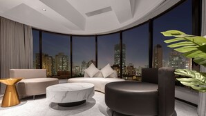 Ein modernes Wohnzimmer mit gewölbter Decke, großen Fenstern, einer Couch, einem Couchtisch und einer Pflanze.