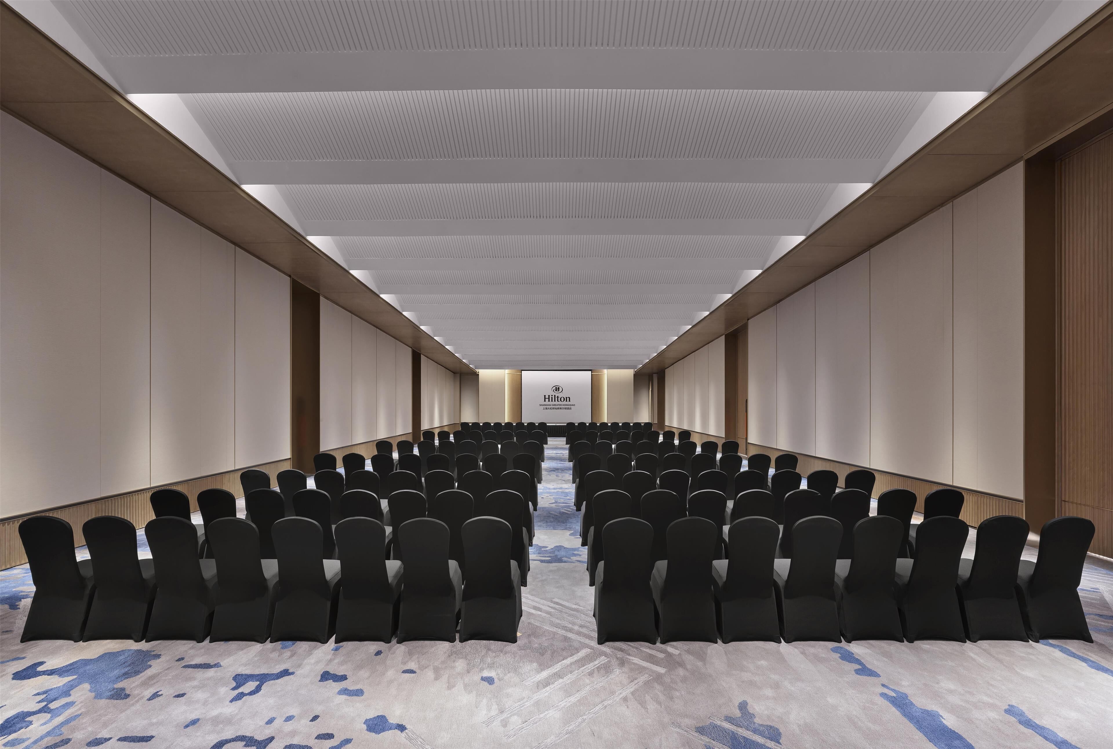 A conference room with rows of chairs and a podium at the front.