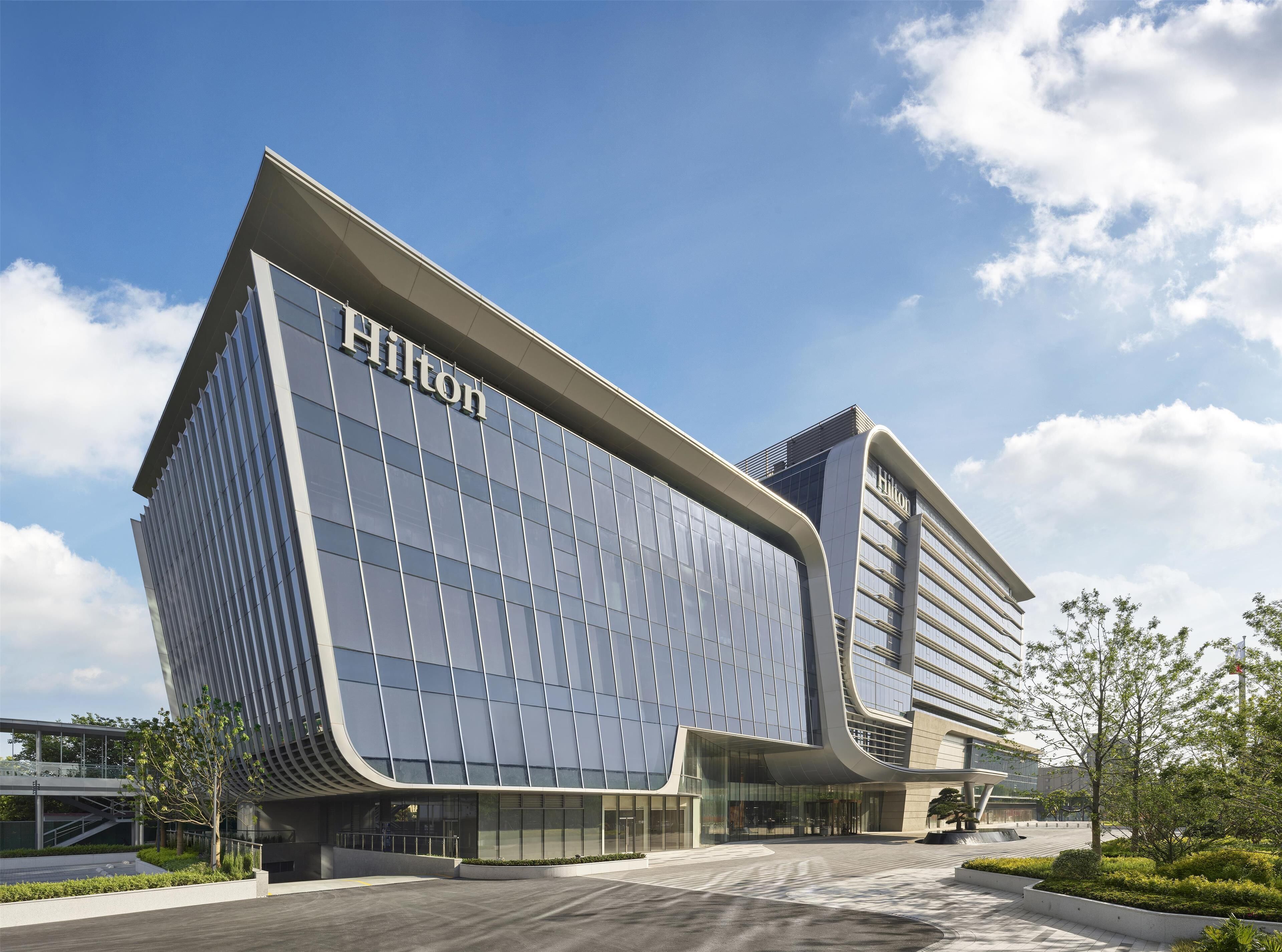 A modern hotel with a curved facade and large glass windows.
