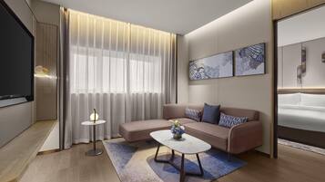 A modern living room with a sofa, coffee table, and artwork on the wall.