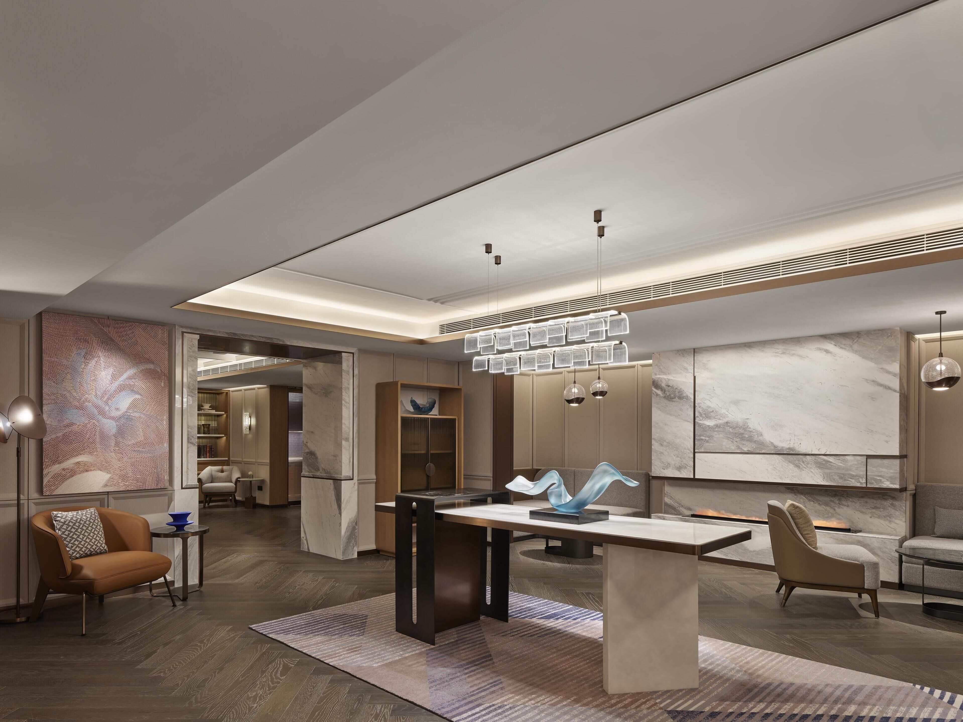 A modern interior with a marble wall, a central table, and contemporary furniture.
