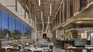 A spacious indoor area with multiple seating arrangements, large windows, and a modern architectural design.