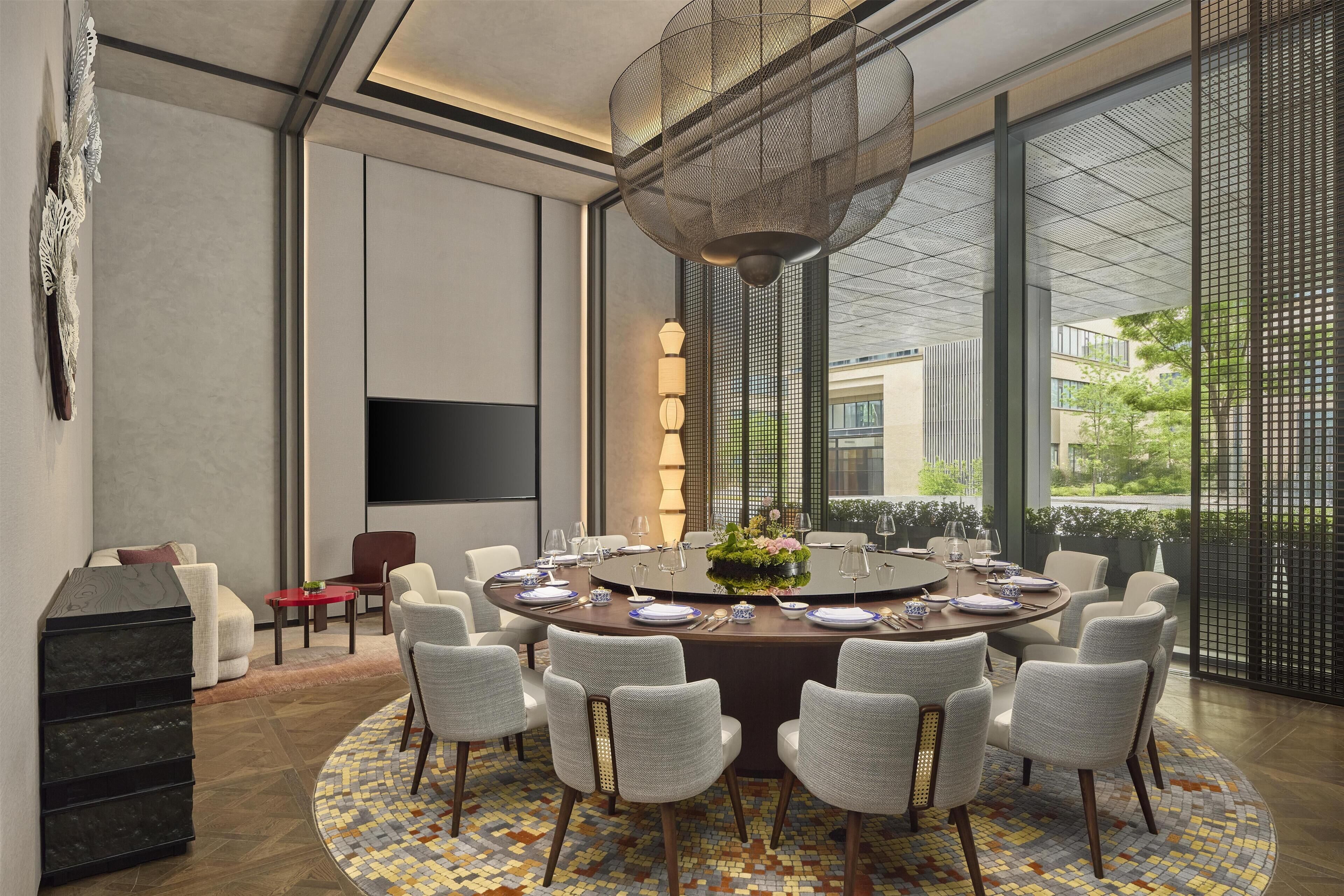 A modern dining area with a round table, chairs, and a decorative centerpiece.