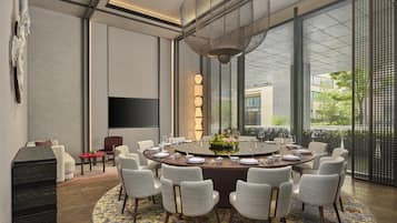 A modern dining area with a round table, chairs, and a decorative centerpiece.
