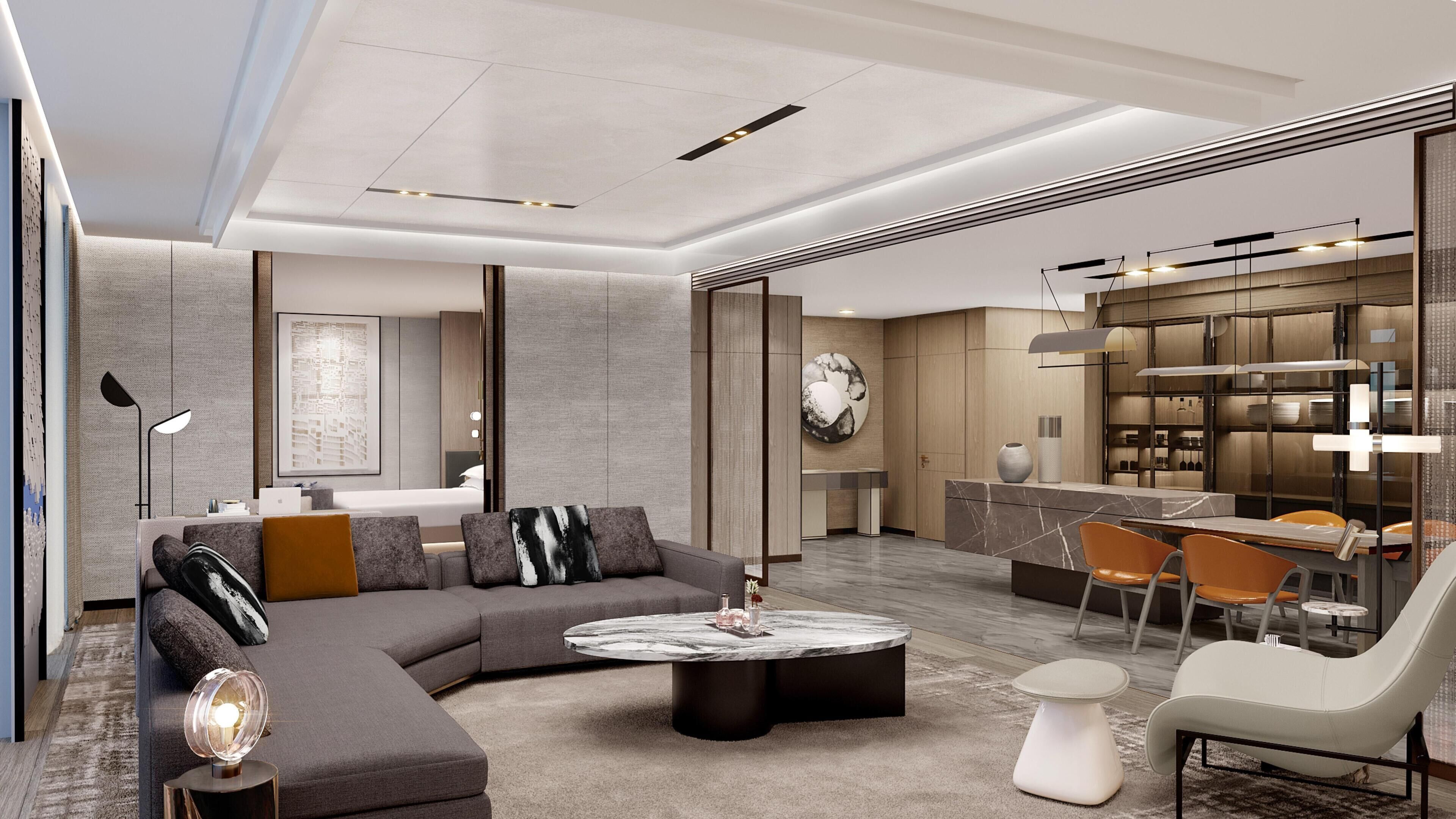 A modern living room with a sectional sofa, a round coffee table, and a dining area with a bar.