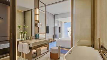 Un baño moderno con una bañera grande, un tocador con espejo y una zona de ducha.