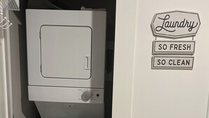 A laundry room with a washing machine and dryer stacked vertically.
