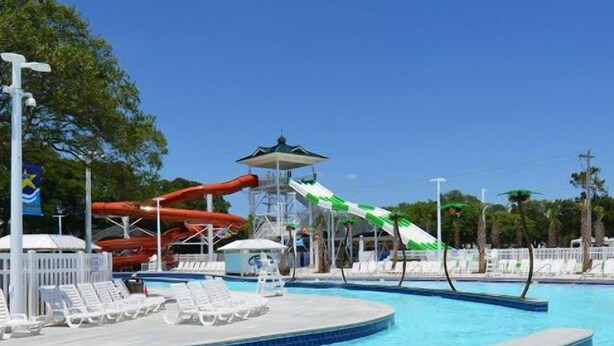 Una piscina con toboganes y sillas de descanso.