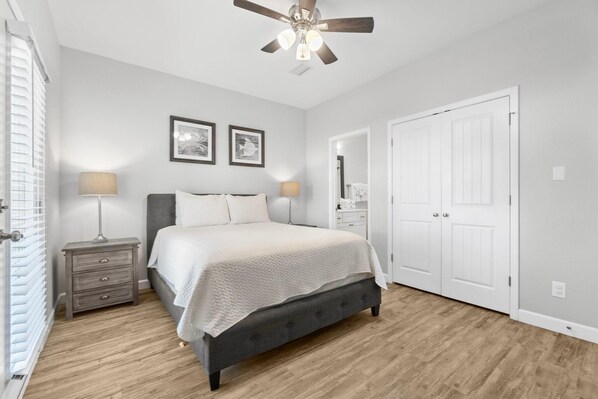 Cozy retreat with a large bed, bedside tables, and a ceiling fan.