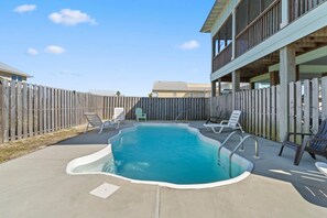 Relax by the pool surrounded by a deck and lounge chairs.
