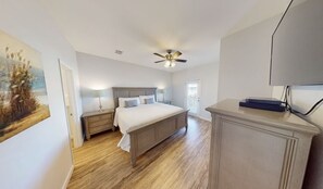 Relax in comfort with a large bed, ceiling fan, and convenient nightstand with lamp.