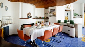 A dining area with a round table set for six, orange chairs, and a blue-tiled floor. - Villa Ambra by My Villa Collection (Casamicciola Terme)
