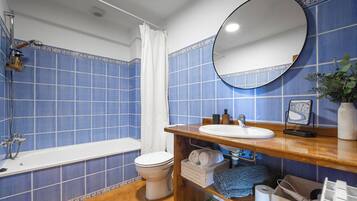 A bathroom with a bathtub, toilet, and sink.