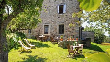 Relax in a serene outdoor setting with a well-maintained lawn, dining area, and hammock.