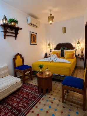 A hotel room with a bed, two chairs, a sofa, a small table, and decorative items. - Riad hamad (Fes)