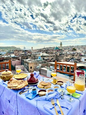 Une table dressée avec des aliments pour le petit-déjeuner et une vue sur le paysage urbain.