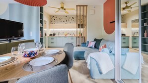 Uma sala moderna com área de jantar, cozinha e um quarto.