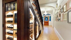 A hallway with a wine cellar, wooden staircase, and a stained glass window. - Nevis Estate Boutique Hotel (Perth)