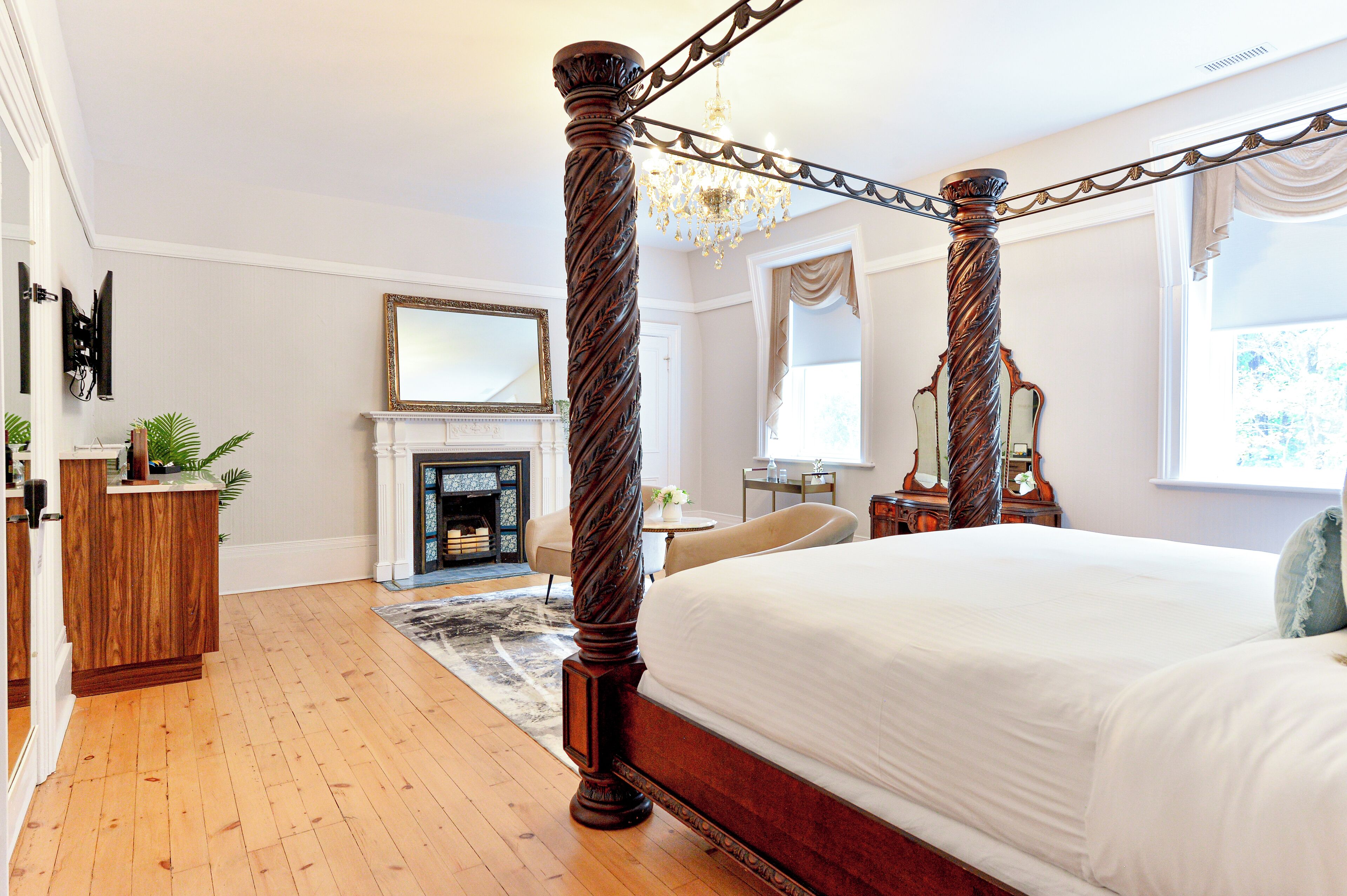 Un dormitorio amplio con una cama con dosel, una chimenea y un candelabro.
