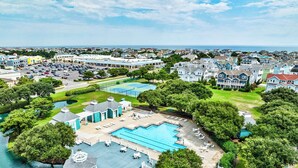 Un grande resort con diverse piscine, un porto turistico e una vegetazione lussureggiante.