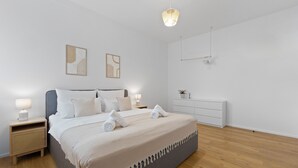 A modern bedroom with a large bed, bedside tables, a dresser, and artwork on the walls. - Central | Modern | Old Town | Parking lot | 70 m² (Bad Kreuznach)