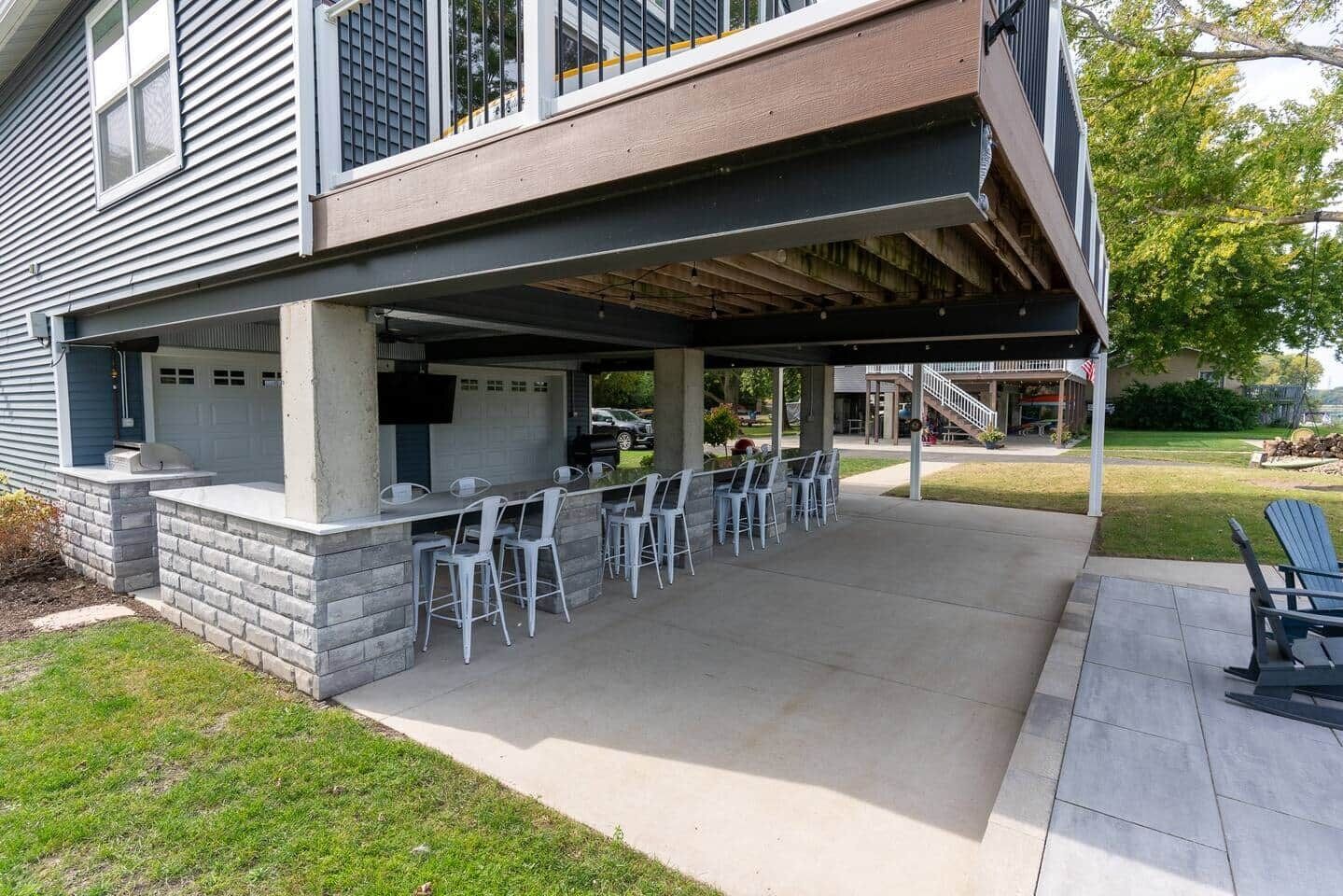 An outdoor patio with a bar area, outdoor seating, and a covered section.