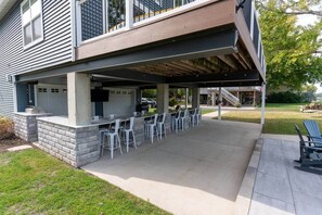Une terrasse extérieure avec un espace bar, des sièges extérieurs et une partie abritée.