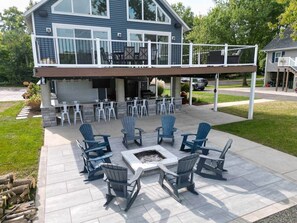 Une maison dotée d’un patio couvert comprenant un espace salon extérieur et un foyer.