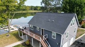 A two-story house with a covered porch, a dock, and a lake view. - Insta-worthy Rock River cabin (Byron)