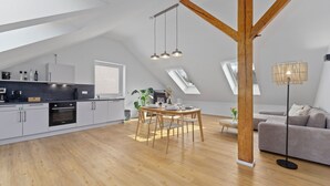 Moderni loft-tyylinen asunto, jossa on keittiö, ruokailutila ja oleskelutila.