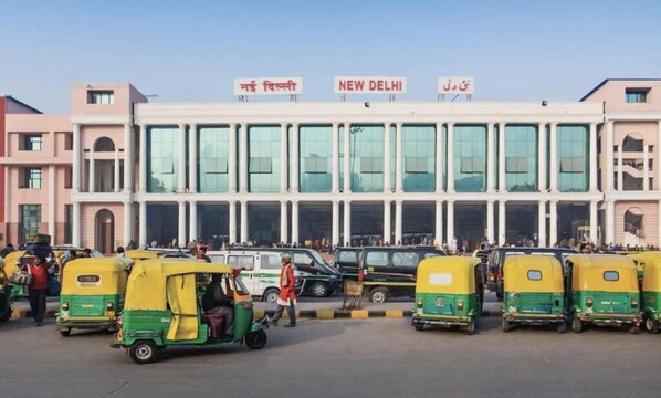 A building with multiple auto-rickshaws in front, and signs reading "NEW DELHI" in English and another language. - Hotel C & G Villa New Delhi (New Delhi)